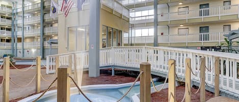 Uma piscina interior em vários níveis, com grades de madeira e uma barreira de corda.