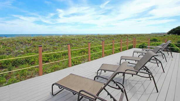 Una terraza con sillones de descanso con vista a la playa.