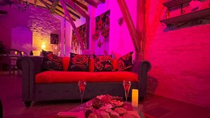 A cozy room with a sofa, a table with food and drinks, and a candle. - Lz Secret du Pigeonnier: The Jewel of Your Desires (Lavaurette)