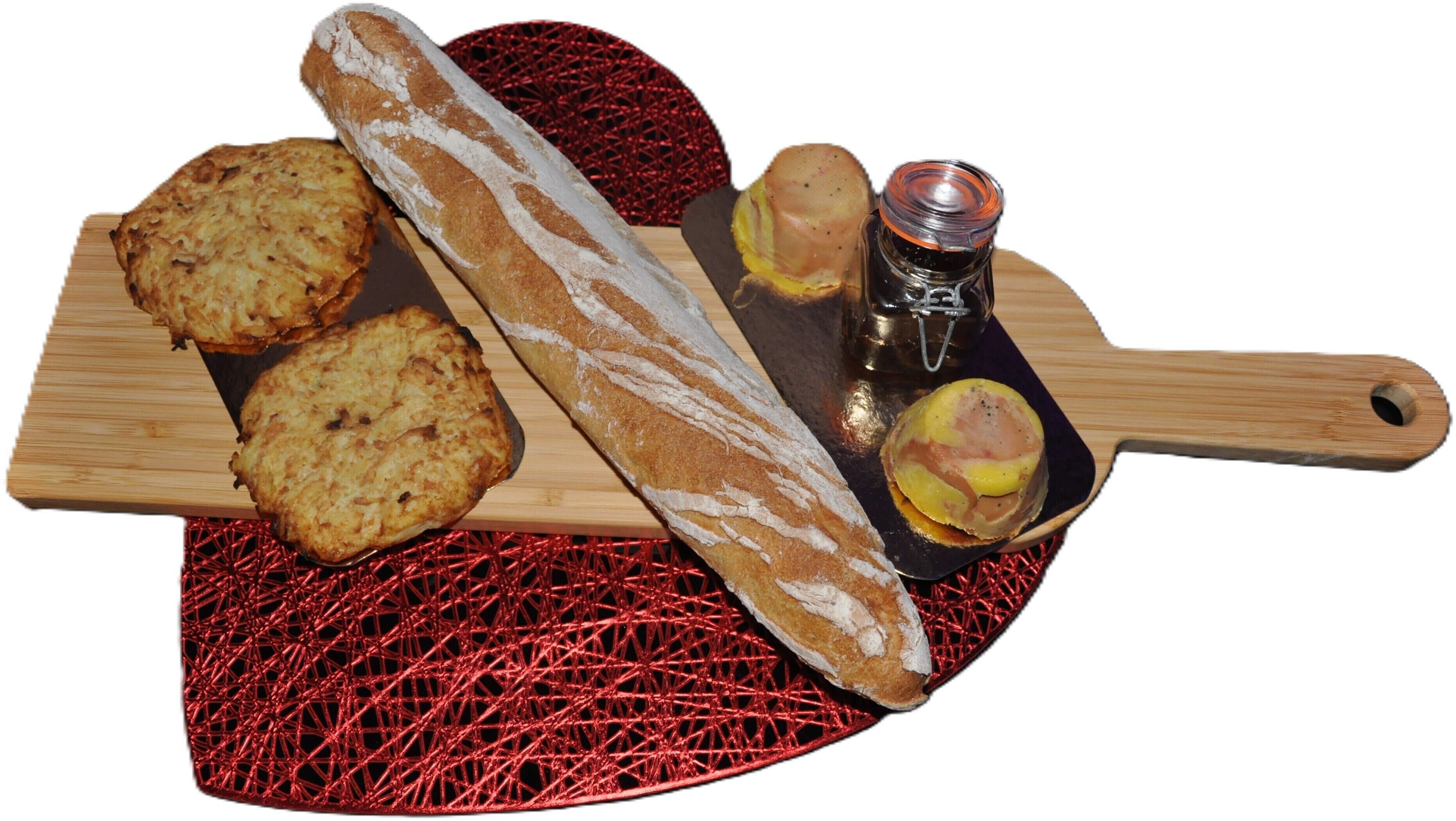 A wooden cutting board with a baguette, two round pastries, and a small bottle.
