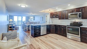 A modern kitchen with dark cabinetry, a built-in microwave, and an oven. - Charming Waterfront Getaway with Seasonal Pool & Hot Tub, Tennis, Beach Access (Hilton Head)