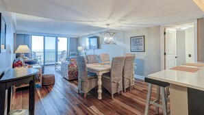 A dining area with wicker chairs, a wooden table, and a view of the outdoors. - Charming Waterfront Getaway with Seasonal Pool & Hot Tub, Tennis, Beach Access (Hilton Head)