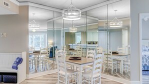 Una cucina moderna con zona pranzo, ampie finestre e un muro a specchio.