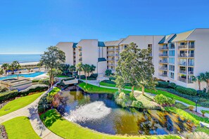 Ein Resort mit Schwimmbad, Teich und Meerblick.