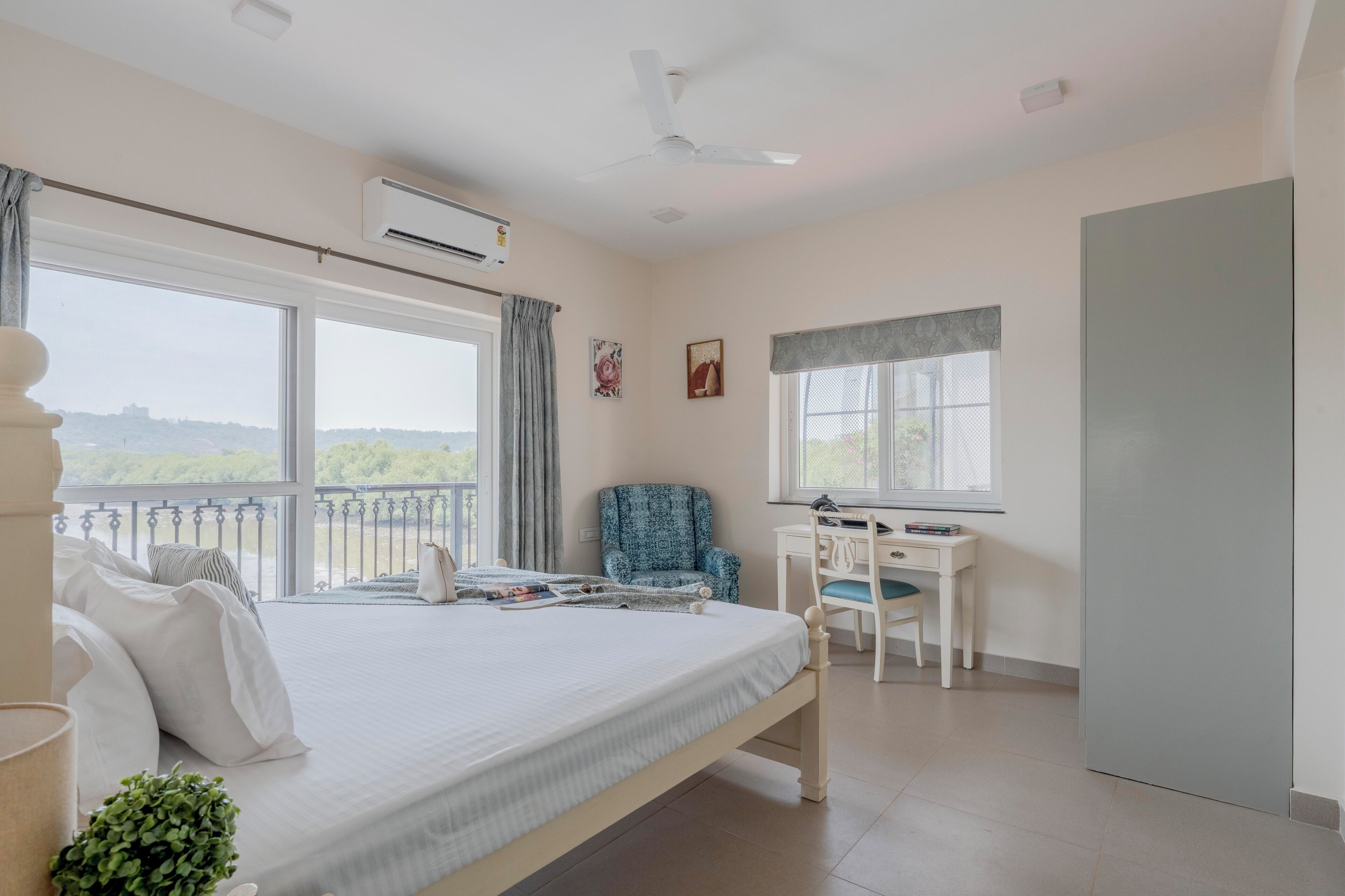 Une chambre à coucher avec un lit, un bureau, une chaise et un balcon.