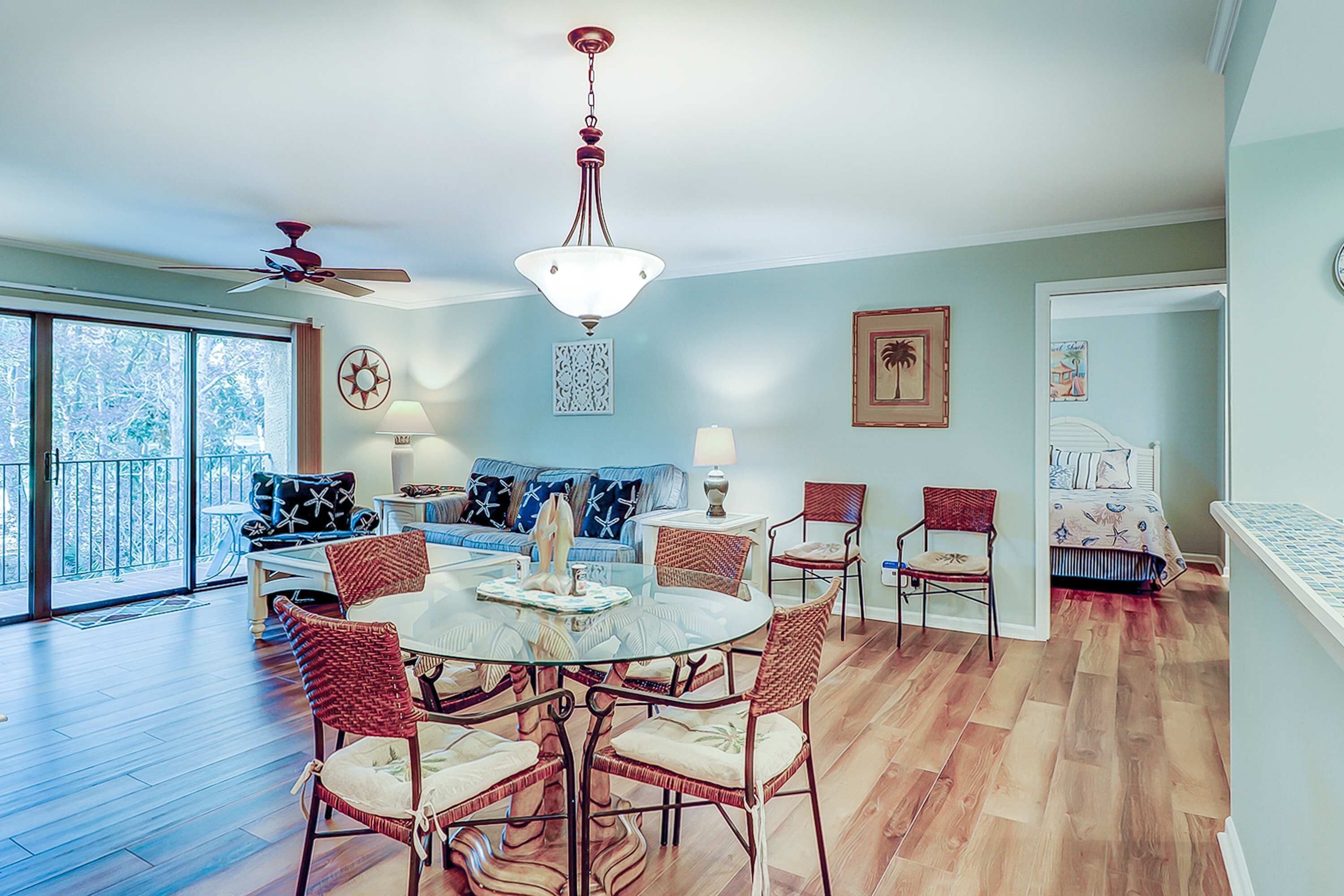 A dining area with a round table, chairs, and a ceiling fan.