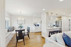 A modern kitchen with white cabinets, a stainless steel refrigerator, and pendant lighting. - George Fazio Golf Course front condo with beach access & on site pool and tennis (Hilton Head)