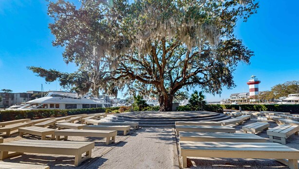 A beachside area with wooden benches and a large tree with hanging moss. - Enchanting condo just steps to golf & Harbour Town Marina (Hilton Head)