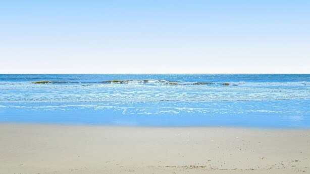 Una spiaggia con acque cristalline e una costa sabbiosa.