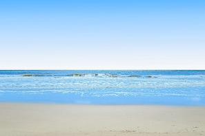 Ein Strand mit klarem Wasser und sandigem Ufer.