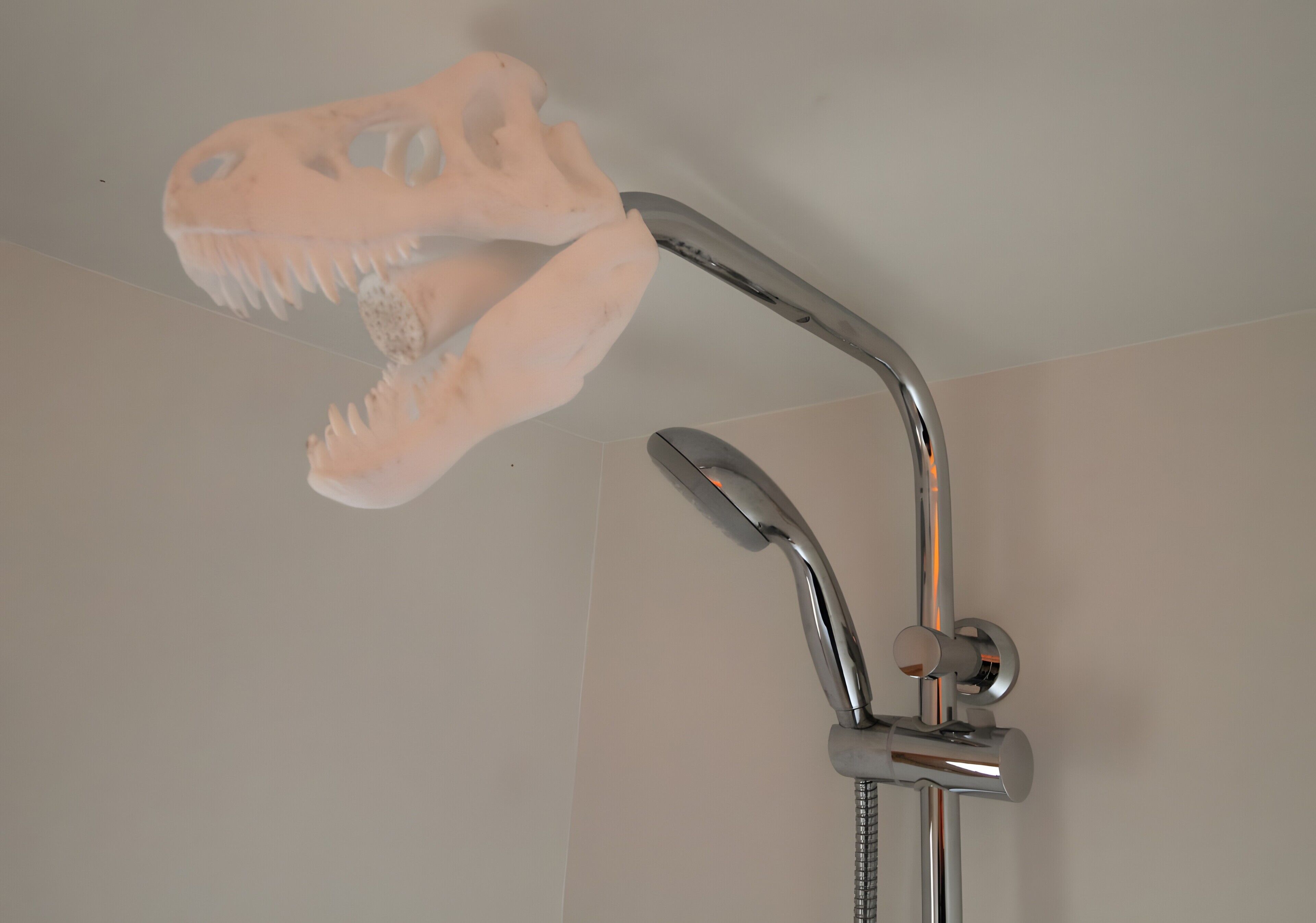 Een douche met een douchekop in de vorm van een dinosaurus.