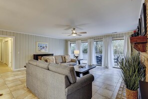 Ein Wohnzimmer mit Sofa, Tisch, Lampe und Deckenventilator.