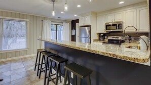 A kitchen with a granite countertop, stainless steel appliances, and pendant lighting. - Breezy resort home located in Sea Pines Resort near marina & restaurants (Hilton Head)