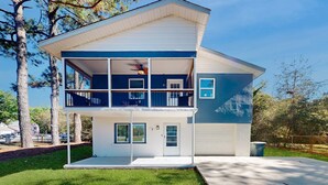 A two-story house with a balcony, a garage, and a lawn. - Spacious house by the beach with screened balcony & central AC (Hilton Head)