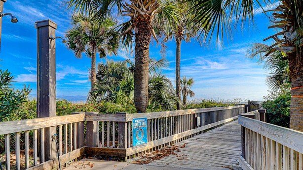 A wooden boardwalk with a sign indicating it is a pedestrian path.