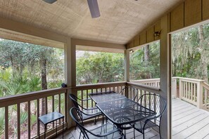 A covered outdoor area with a table and chairs, surrounded by wooden railings and trees. - Recently Updated Resort Villa with WiFi & Pool - Quick Walk to Beach (Hilton Head)