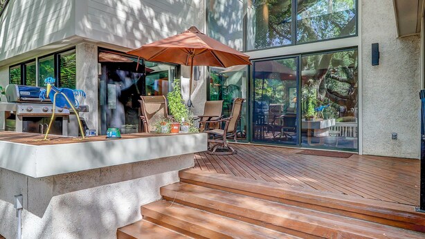 A deck with a grill, outdoor furniture, and a large umbrella. - 2-story house with private heated outdoor pool, stunning views & foosball (Hilton Head)