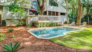 A modern two-story house with a swimming pool, surrounded by trees and a well-maintained lawn. - 2-story house with private heated outdoor pool, stunning views & foosball (Hilton Head)