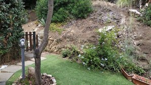 A garden with a wooden bench, a tree, and a stone pathway. - Panoramic Costa Rei (MURAVERA CA)