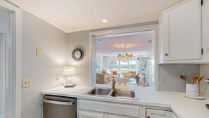 A kitchen with a dishwasher, double sink, and cabinets. - Coastal resort style villa with pool, golf, & balcony  WD, AC, & dog friendly (Hilton Head)