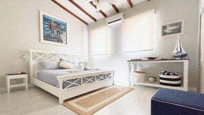 Een slaapkamer met een bed, nachtkastjes, een plank met decoratieve voorwerpen en een schilderij aan de muur.
