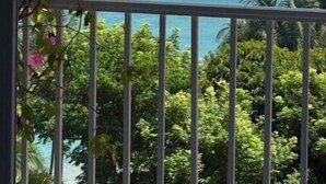 Een balkon met uitzicht op de oceaan en een rotsachtig eiland.