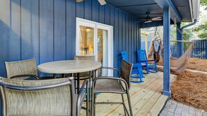 A covered patio with a table and chairs, a ceiling fan, and a view of the backyard. - 3 bedroom home Palm lined hideaway with pool and Dog Friendly (Hilton Head)