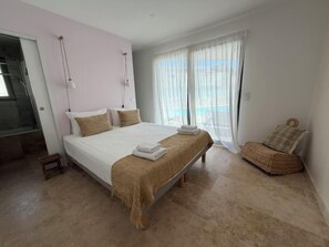 A bedroom with a large bed, a chair, and a view of the outdoors. - Villa Solaya - Private Pool in Isle-sur-la-Sorgue (L'Isle-sur-la-Sorgue)