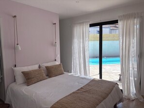 A bedroom with a bed, two bedside lamps, a view of a swimming pool through a glass door. - Villa Solaya - Private Pool in Isle-sur-la-Sorgue (L'Isle-sur-la-Sorgue)