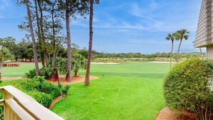 Un campo de golf con vista despejada al fairway, búnkeres de arena y árboles circundantes.