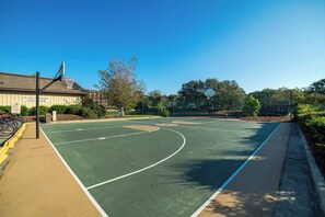 An outdoor basketball court with a fence, trees, and a building labeled 'Island Club Tennis & Health Club' in the background. - Quiet Waterfront Condo with WiFi - Pools & Hot Tub On-Site (Hilton Head)