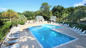 A swimming pool with lounge chairs, a covered area, and surrounding greenery. - Intimate, Yet Spacious Villa with Shared Pool and Tennis - Walk to the Beach (Hilton Head)