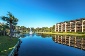 Ein Hotel mit einem Teich, einer Fontäne und einer Palme.