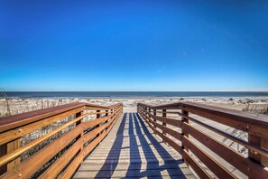 A wooden boardwalk leading to a beach with clear skies. - Pet Friendly Beach Getaway with Private Pool & Big Backyard Easy Walk to Beach (Hilton Head)