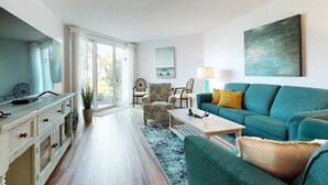 Ein Wohnzimmer mit Sofa, Couchtisch und Essbereich mit Schrank.