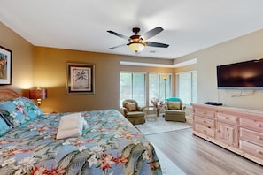 A bedroom with a bed, a ceiling fan, a TV, a dresser, and a chair. - Conveniently Located Condo with Shared Pool and Tennis Court, Private WD, Free WiFi (Hilton Head)