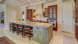 A spacious kitchen with a large island, wooden cabinets, and pendant lighting. - Two-story home with pool, balcony, deck, grill, & central AC - snowbirds welcome (Hilton Head)