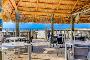 A beachside restaurant with outdoor seating, a thatched roof, and a view of the ocean. - Home with private pool, fenced in yard, dog-friendly, walk to beach (Hilton Head)