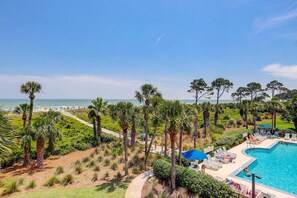 A resort with a swimming pool, lounge chairs, and a view of the beach. - First Floor Condo near the beach with beach gear, washer and dryer, and pool (Hilton Head)