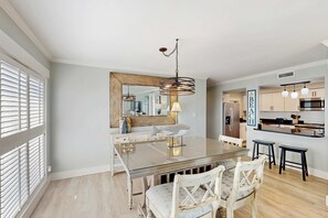 A modern kitchen with a central island, pendant lighting, and a large mirror above the island. - First Floor Condo near the beach with beach gear, washer and dryer, and pool (Hilton Head)