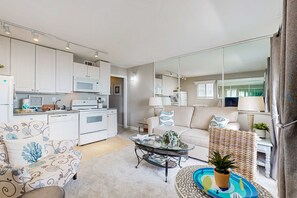 A modern living room with a sofa, coffee table, and a dining area with a microwave and oven. - Water front Condo Pools, Tennis, Fitness Center  Walk 5 Minutes to Beach (Hilton Head)