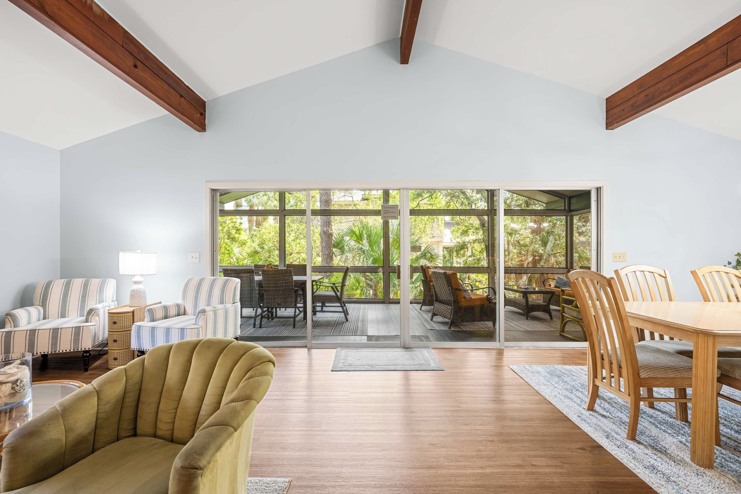 A spacious living room with a large sliding glass door leading to an outdoor patio area.
