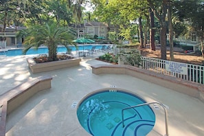 A pool area with a lifeguard duty sign, lounge chairs, and a palm tree. - Spacious Condo with Shared Pool, Tennis, Golf & Beach Access (Hilton Head)