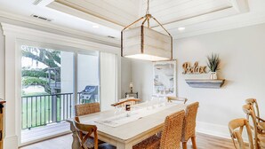 A dining area with a large table, wicker chairs, a hanging light fixture, and a 'Relax' sign on the wall. - Delightful getaway with golf course views, private pool, and high-speed WiFi (Hilton Head)