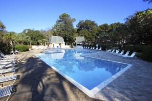 A rectangular swimming pool with a tiled deck, surrounded by lounge chairs and trees. - Dog-friendly, golf-course adjacent townhouse w a wet bar, patio, & shared pool (Hilton Head)