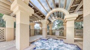 A hot tub area with a view of trees, surrounded by beige pillars and a metal roof. - Island Bliss Near the Beach with Golf On Site, Shared Pool,Hot Tub & Private Deck (Hilton Head)