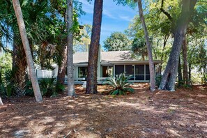 A house surrounded by trees with a visible deck and a covered outdoor area. - Spacious Home - four rows from the ocean with private deck (Hilton Head)