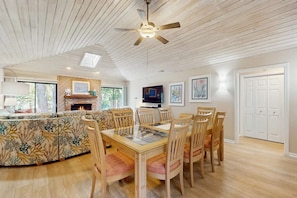 A spacious dining area with a glass-top table, wooden chairs, and a ceiling fan. - Spacious Home - four rows from the ocean with private deck (Hilton Head)