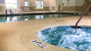 Ein Hallenbad mit Whirlpoolbereich, ausgewiesenen Wassertiefen und Schildern, die das Sprungverbot anzeigen.