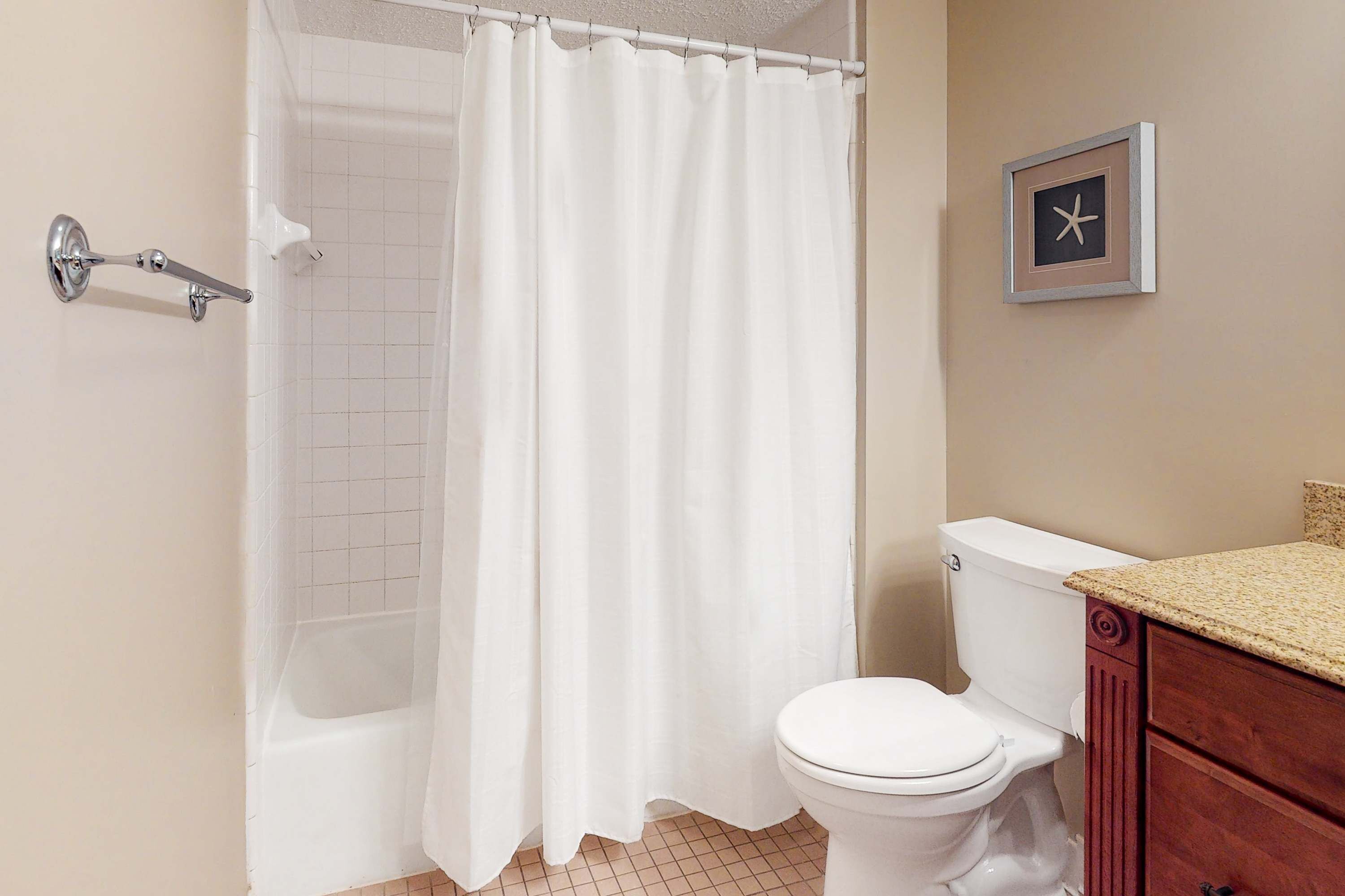 Une salle de bain avec une baignoire blanche, des toilettes blanches et un meuble-lavabo en bois.